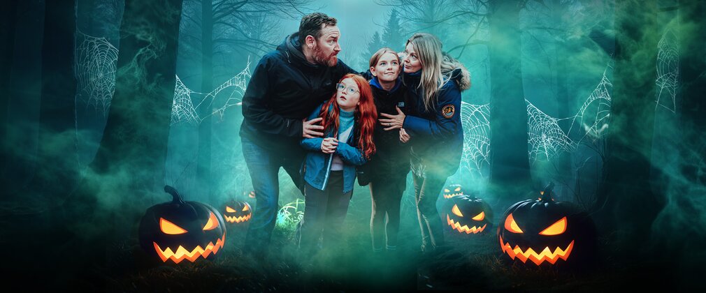A family surrounded by pumpkins and trees