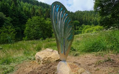 A mental and glass sculpture of a dragonfly wing