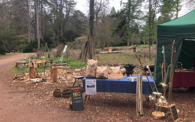A table with a blue cloth has been covered in coppice products ready to sell.
