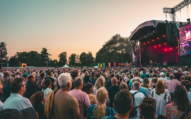 An outdoor concert stage with crowd at dusk