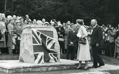 A black and white archive photo showing Queen Elizabeth II unveiling a commemorative plaque.
