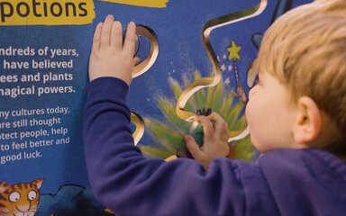 Close-up of a young boy playing with an interactive board.