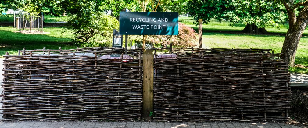 A wicker fence encases the recycling and waste bins for Westonbirt Arboretum