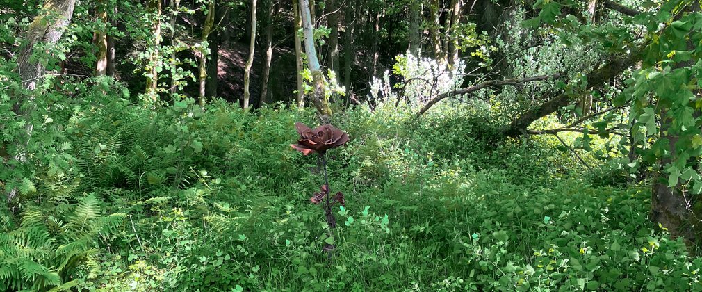 A metal flower sculpture in the forest