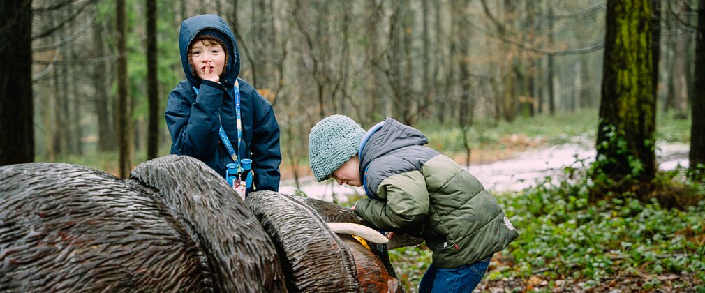 Two boys next to a carved Gruffalo sculpture