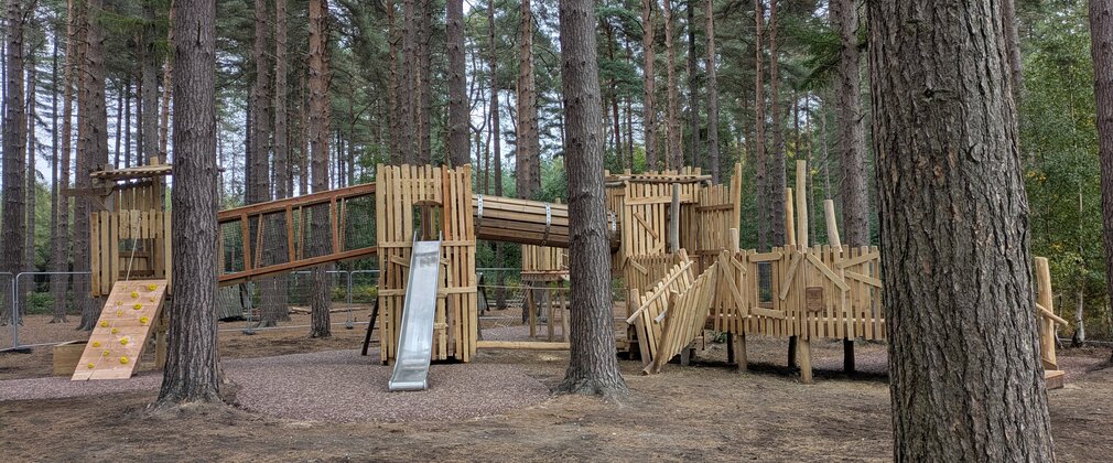 Robin Hood's Hide Out - a wooden play structure featuring bridges, slides and climbing elements.
