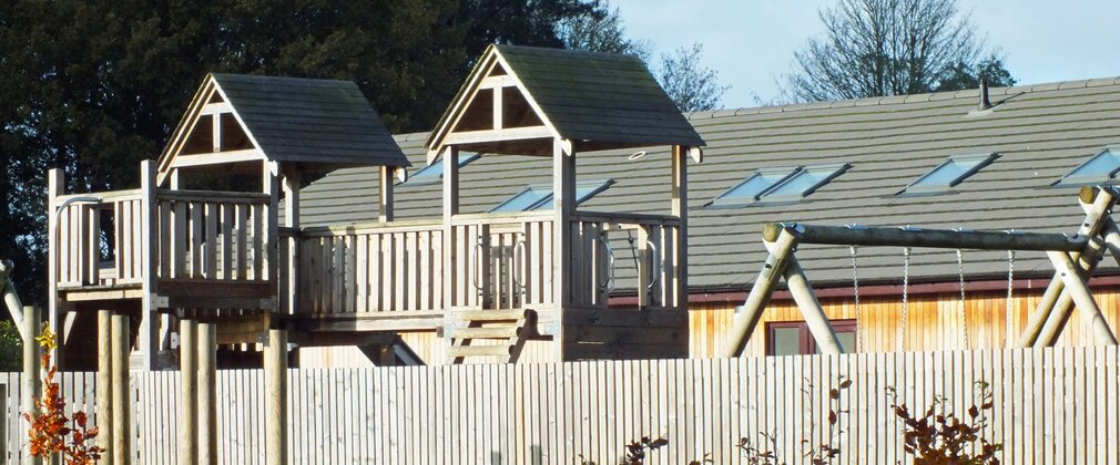 Childen's play area with wooden swings and climbing frame