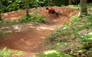 Mountain bike rider on a berm in a forest