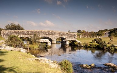 Bridge crossing small river on bright sunny day