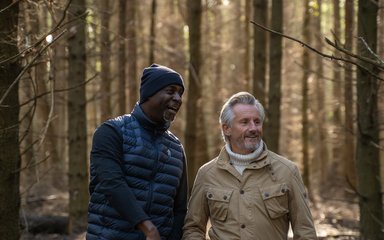 Two men in the forest having a chat and smiling