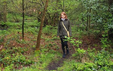 Woman walking in woods footpath