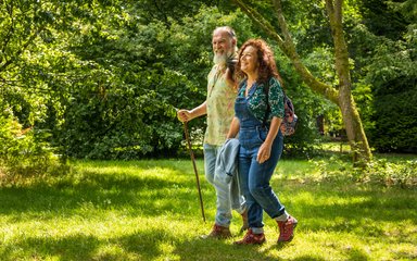 Couple walking on bright green grass looking content