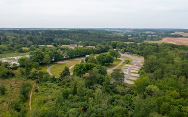 Drone shot of Fineshade Campsite - trees surrounding hard standing plots