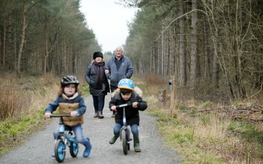 Family walking with boys on balance bikes