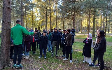 A member of Forestry England staff talks to a group of people in the forest