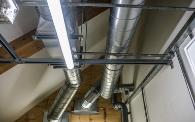 2 large silver tubes run along the ceiling and to a wall