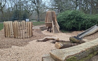 Wooden play feature with a hide and seek theme made out of wood from the arboretum
