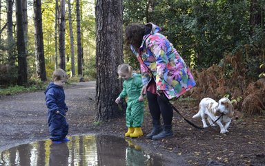 Children playing in puddles on a forest trail at Alice Holt Forest 