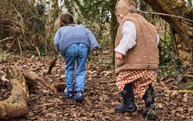 two small children exploring woodland