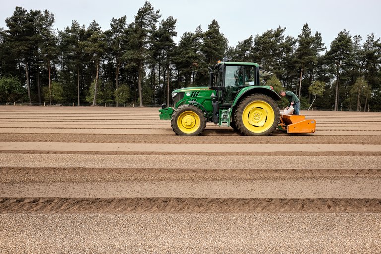 Tractor driving through empty field 