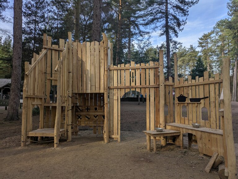 A wooden play fortress in a forest setting